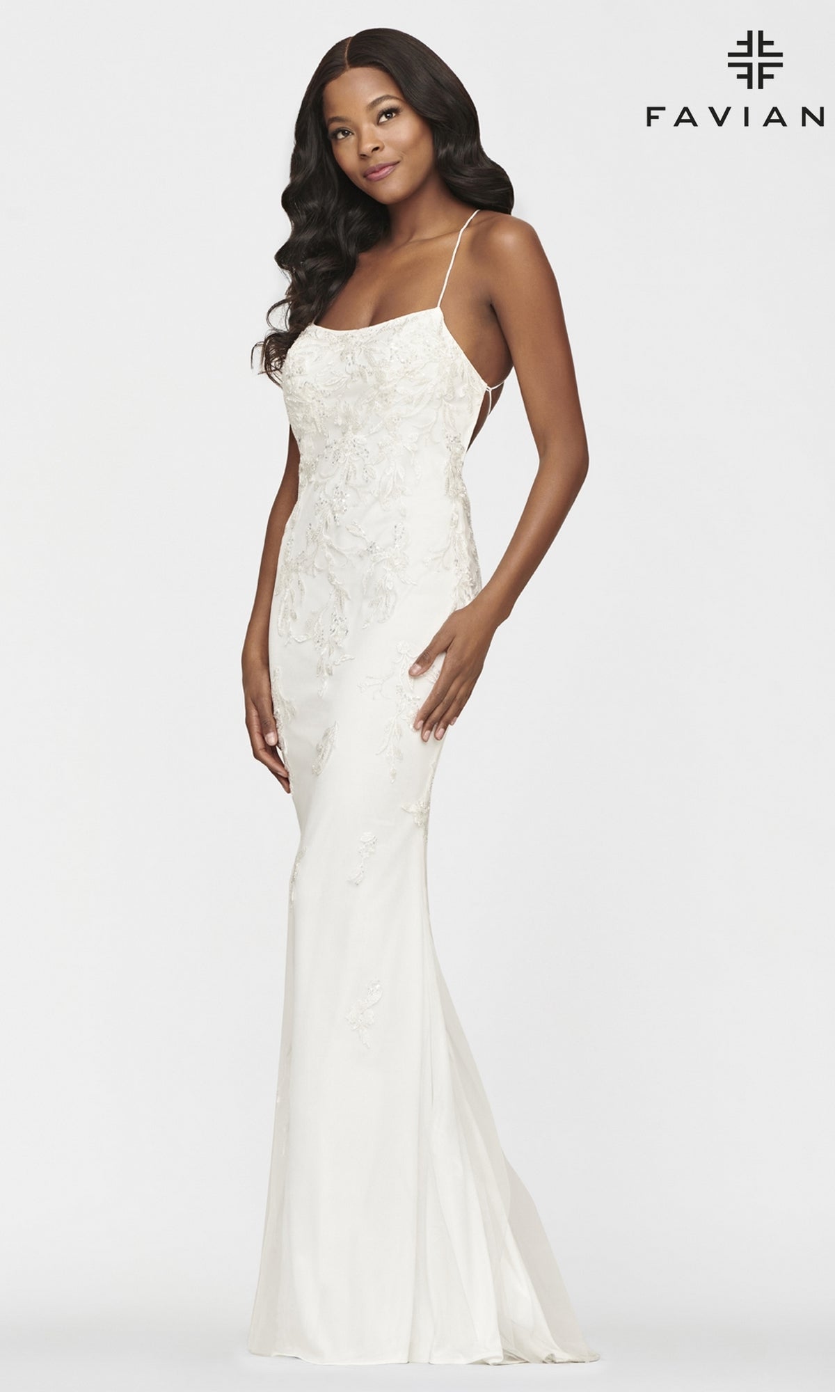 A woman models the Strappy Open-Back Long Yellow Faviana Prom Dress, featuring thin straps and a fitted silhouette, standing before a plain background with